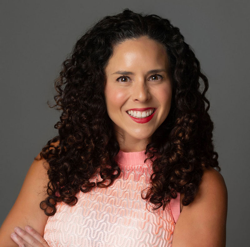 Dr. Ssarah Berg, guest on Health Dame, is smiling with dark curly brown hair wearing a coral tank top.